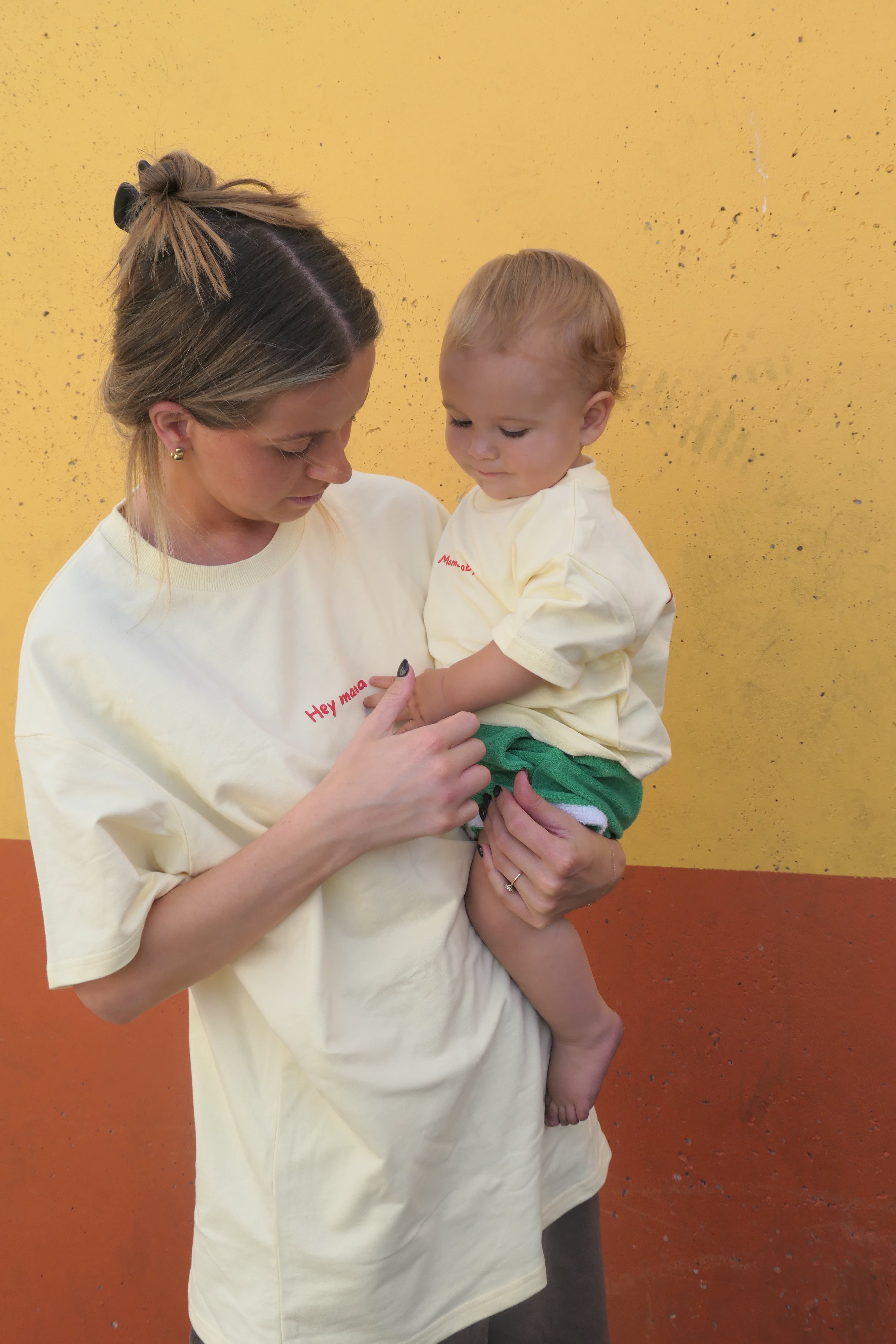 Woman and child in yellow matching t-shirts 'hey mama' & 'mama's baby' 